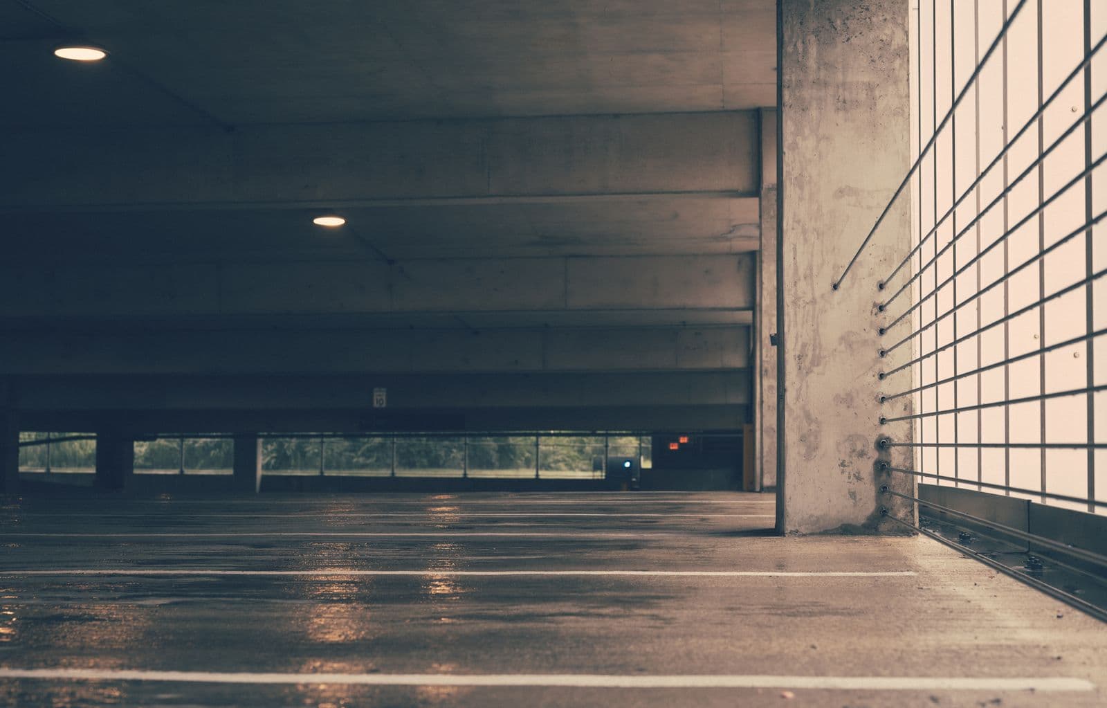 Wet concrete floor with a standing-water sheen reflecting ceiling lights
